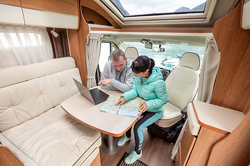 Image showing Couples in RV Camper looking at the local map for the trip.