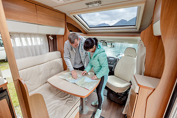 Image showing Couples in RV Camper looking at the local map for the trip.