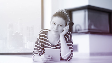 Image showing woman using tablet computer in front of fireplace