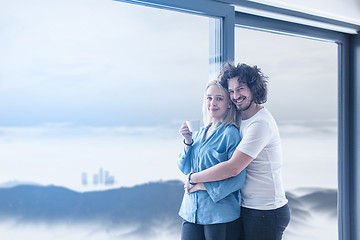 Image showing young couple enjoying morning coffee by the window