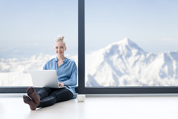 Image showing woman drinking coffee and using laptop at home