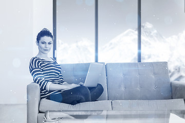 Image showing young woman on sofa at home websurfing