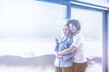 Image showing young couple enjoying morning coffee by the window