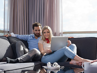 Image showing couple relaxing at  home using laptop computer