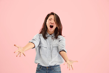 Image showing The young emotional angry woman screaming on studio background