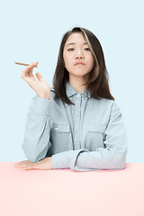 Image showing Handsome young women smoking cigar while sitting at table with newspaper in sunglasses