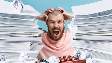 Image showing Frustrated overwhelmed executive working in the office and overloaded with paperwork