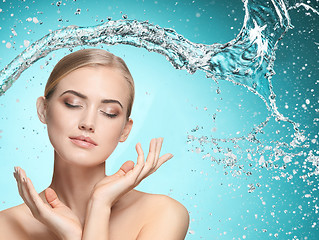 Image showing Beautiful female model with splashes of water in her hands.