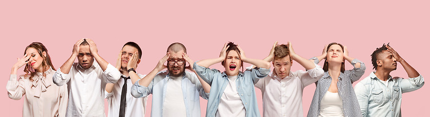 Image showing People having headache. Isolated over pink background.