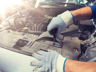 Image showing mechanic man with wrench repairing car at workshop