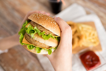 Image showing close up of woman holding hamburger
