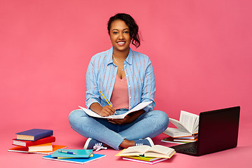 Image showing african american student woman writing to notebook