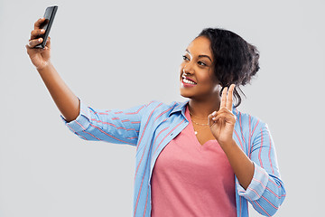 Image showing african american woman taking selfie by smartphone