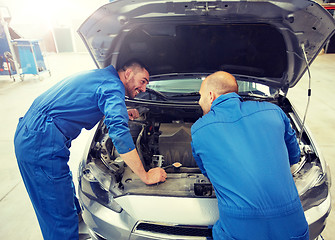 Image showing mechanic men with wrench repairing car at workshop