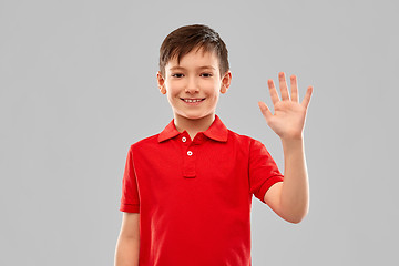 Image showing portrait of smiling boy in red t-shirt waving hand