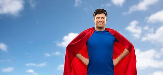 Image showing man in red superhero cape over sky background