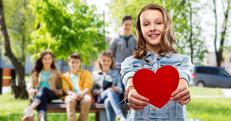 Image showing smiling teenage girl with red heart outdoors