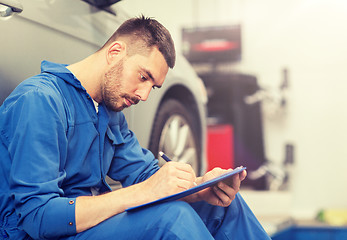 Image showing auto mechanic man with clipboard at car workshop