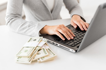 Image showing close up of businesswoman with laptop and money