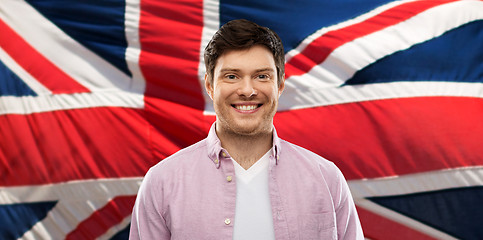 Image showing smiling young man over british flag background