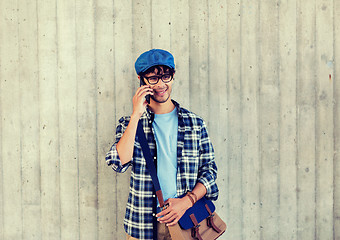 Image showing man with bag calling on smartphone at street wall