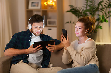 Image showing couple with gadgets listening to music at home