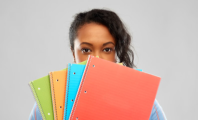 Image showing shy african american student woman with notebooks