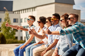 Image showing friends in sunglasses showing thumbs up in city