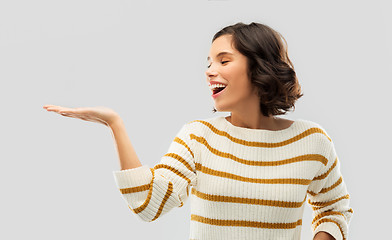 Image showing smiling young woman holding empty palm