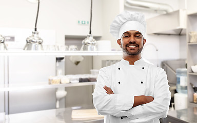 Image showing happy indian chef in toque at restaurant kitchen