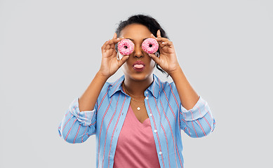 Image showing happy african american woman with eyes of donuts