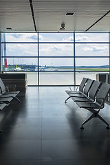 Image showing Empty chairs in airport terminal with view to airplanes.