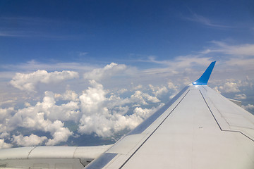 Image showing Wing of the plane on blue sky cloudy background.