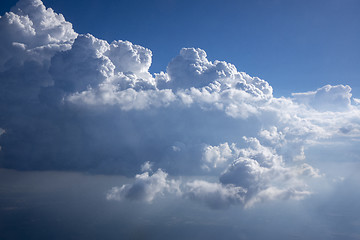 Image showing Sun beams are lighting huge white cumulus clouds.