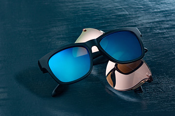 Image showing Two fashionable sunglasses on a blue background.