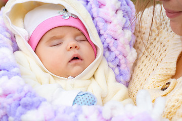 Image showing Portrait of a close-up of a two-month-old girl in her mother\'s arms