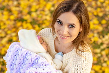 Image showing Mom with a smile walks in the park with the baby and looked into the frame