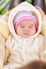 Image showing On the mother\'s lap lies and sleeps two-month-old baby