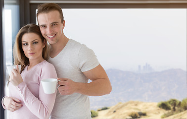 Image showing young couple enjoying morning coffee by the window