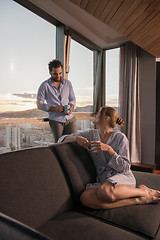 Image showing young couple enjoying evening coffee by the window