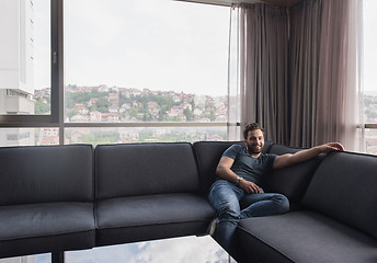 Image showing young casual man using a mobile phone at home