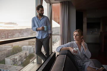 Image showing young couple enjoying evening coffee by the window