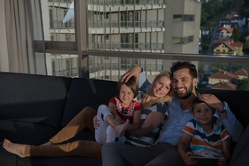 Image showing happy young couple spending time with kids at home