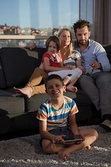 Image showing happy young couple spending time with kids at home