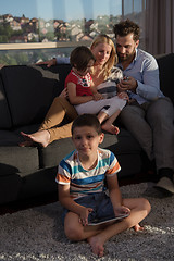 Image showing happy young couple spending time with kids at home