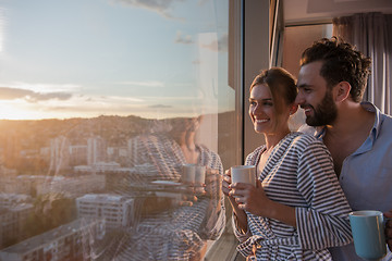 Image showing young couple enjoying evening coffee by the window