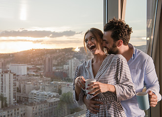 Image showing young couple enjoying evening coffee by the window