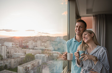 Image showing young couple enjoying evening coffee by the window