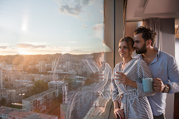 Image showing young couple enjoying evening coffee by the window