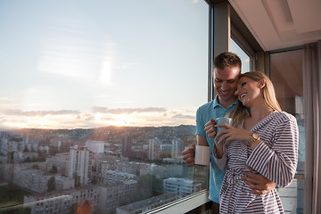 Image showing young couple enjoying evening coffee by the window